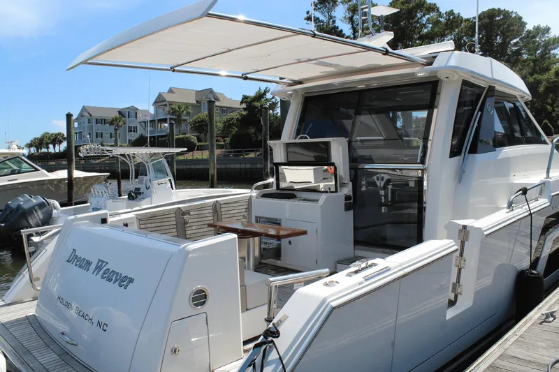 Dream Weaver Yacht Photos Pics 2021 Ocean Alexander 45 Divergence Coupe docked, featuring outdoor seating and grill area.