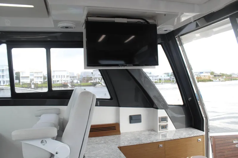 Dream Weaver Yacht Photos Pics Interior of 2021 Ocean Alexander 45 Divergence Coupe with TV and seating by large windows.