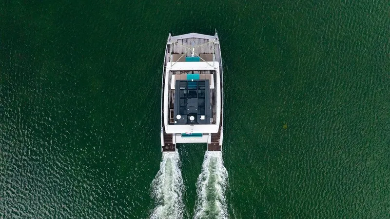 Island Majesty Yacht Photos Pics Aerial view of 2018 Sunreef 70 catamaran cruising on green water.