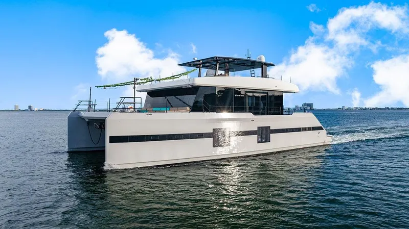 Island Majesty Yacht Photos Pics Luxurious 2018 Sunreef 70 yacht cruising on open water under a clear blue sky.