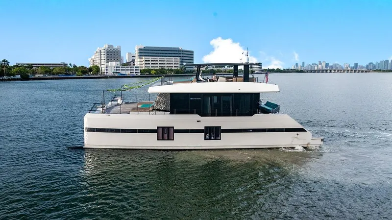 Island Majesty Yacht Photos Pics Luxurious 2018 Sunreef 70 yacht cruising on a calm river with cityscape background.
