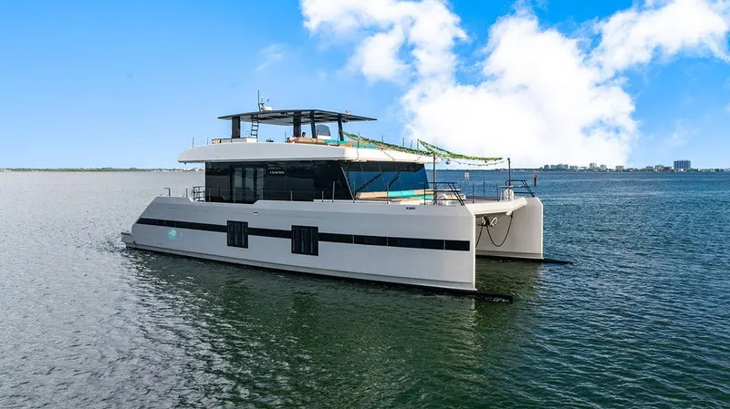 Island Majesty Yacht Photos Pics Luxurious 2018 Sunreef 70 catamaran on calm waters under a clear blue sky.