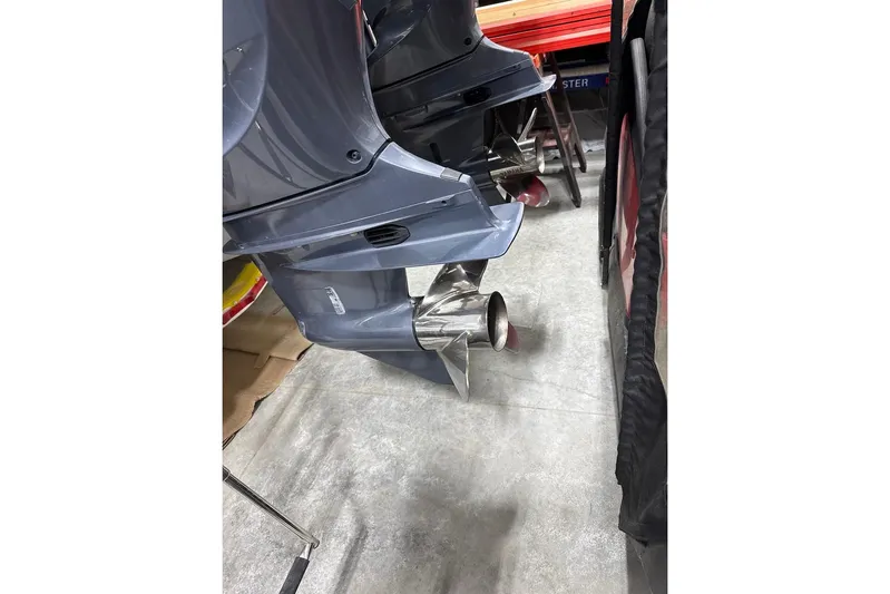  Yacht Photos Pics 2023 Cobia 301 Center Console boat engines with stainless steel propellers in a workshop.