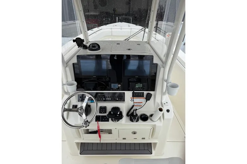  Yacht Photos Pics 2023 Cobia 301 Center Console boat dashboard with steering wheel and navigation screens.