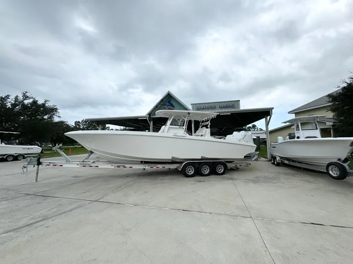  Yacht Photos Pics 2025 Fountain 34TE boat on trailer at dealership under cloudy sky.