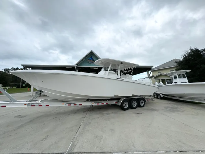  Yacht Photos Pics 2025 Fountain 34TE boat on trailer, parked outdoors under cloudy sky.