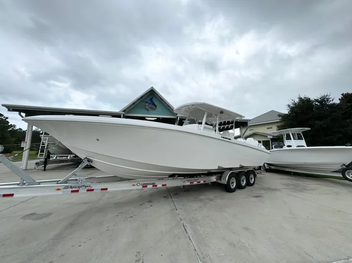  Yacht Photos Pics 2025 Fountain 34TE boat on trailer, parked outdoors under cloudy sky.