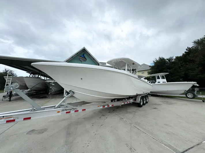  Yacht Photos Pics 2025 Fountain 34TE boat on trailer, parked outdoors under cloudy sky.