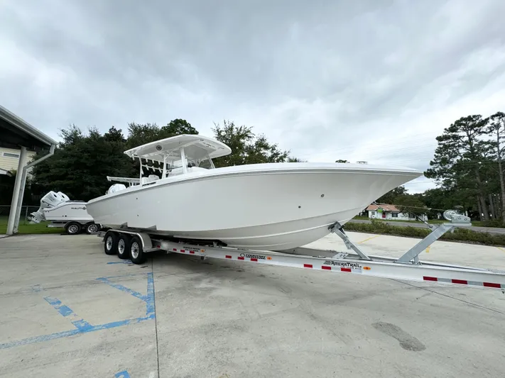 Yacht Photos Pics 2025 Fountain 34TE boat on trailer, parked outdoors under cloudy sky.