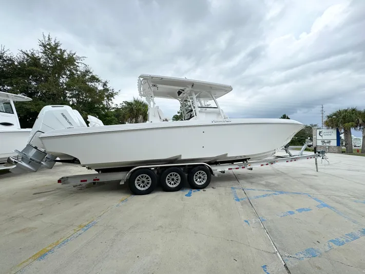  Yacht Photos Pics 2025 Fountain 34TE boat on trailer, parked outdoors under cloudy sky.
