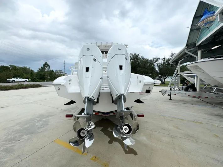  Yacht Photos Pics 2025 Fountain 34TE boat with dual outboard engines, parked outdoors under cloudy skies.