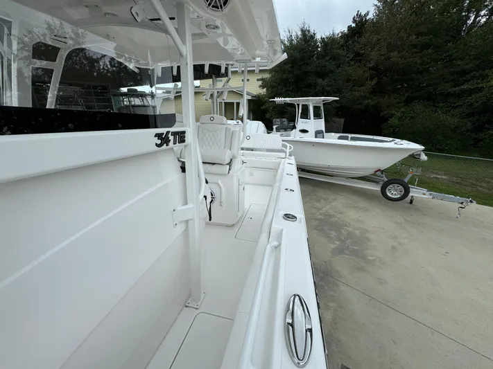  Yacht Photos Pics 2025 Fountain 34TE boat, sleek white design, parked on a trailer.