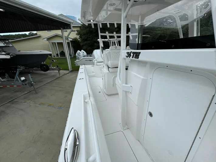  Yacht Photos Pics 2025 Fountain 34TE boat docked, showcasing sleek white design and spacious deck.