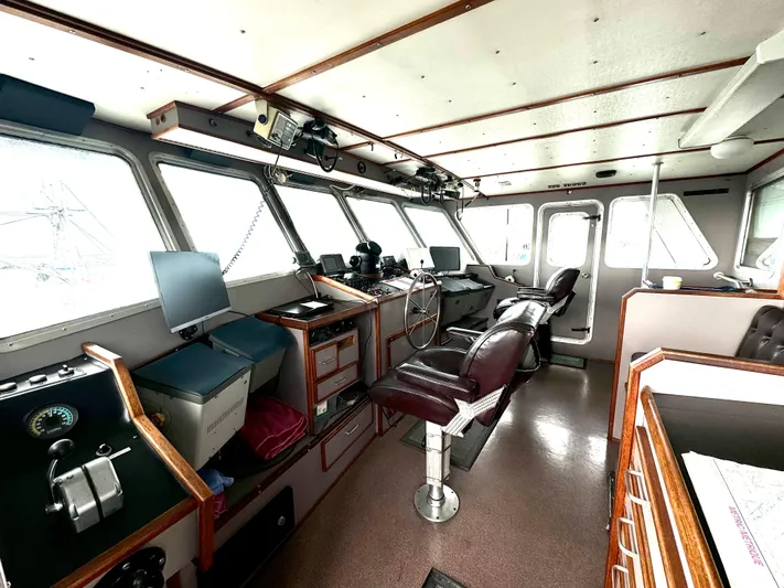 Western Shore Yacht Photos Pics Interior of a 1989 custom expedition yacht's helm with navigation equipment and seating.