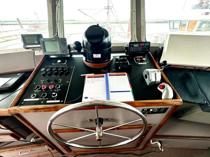 Western Shore Yacht Photos Pics Control panel of a 1989 Custom Expedition Yacht with navigation instruments and steering wheel.