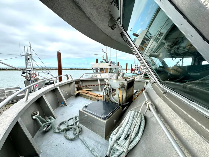 Western Shore Yacht Photos Pics 1989 Custom Expedition Yacht docked, showcasing deck and ropes under cloudy sky.