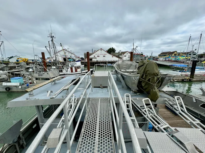 Western Shore Yacht Photos Pics Expedition yacht docked at a marina, surrounded by various boats under cloudy skies.