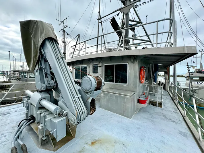 Western Shore Yacht Photos Pics Expedition yacht from 1989 with crane, docked at marina under cloudy sky.
