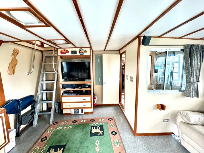 Western Shore Yacht Photos Pics Interior of 1989 Custom Expedition Yacht with TV, ladder, and decorative rug.
