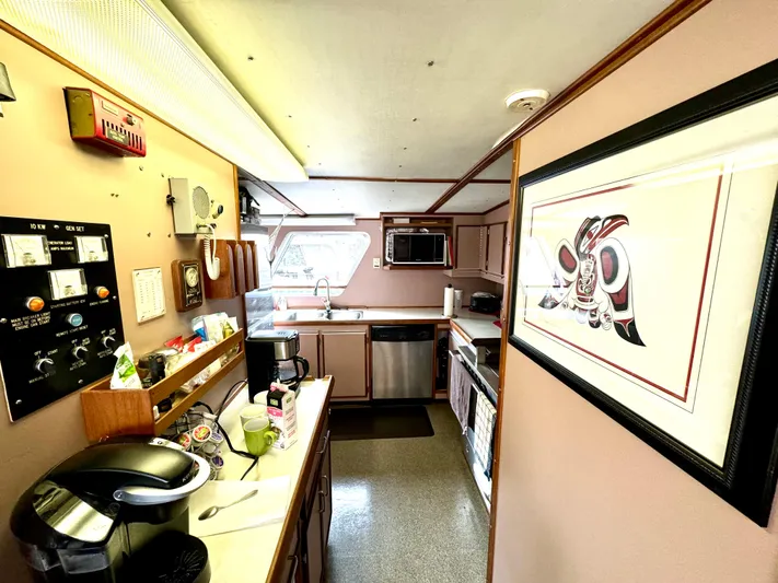 Western Shore Yacht Photos Pics Kitchen interior of 1989 Custom Expedition Yacht with modern appliances and framed artwork.
