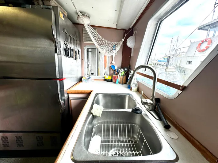 Western Shore Yacht Photos Pics Compact kitchen on 1989 custom expedition yacht with stainless steel sink and large fridge.