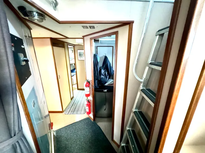Western Shore Yacht Photos Pics Interior of a 1989 custom expedition yacht with hallway, ladder, and fire extinguishers.