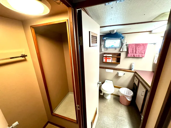 Western Shore Yacht Photos Pics 1989 Custom Expedition Yacht bathroom with shower, toilet, and storage, featuring a window and pink towel.