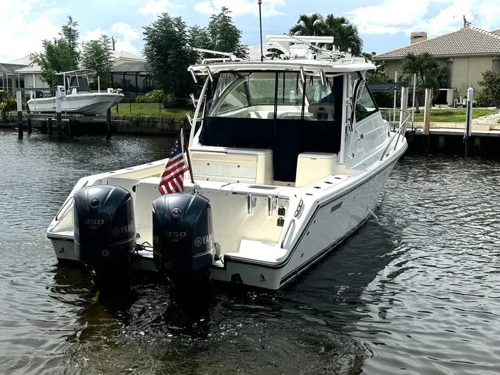 Liberty Yacht Photos Pics 2010 Pursuit OS 345 Offshore boat with twin Yamaha engines docked in a canal.