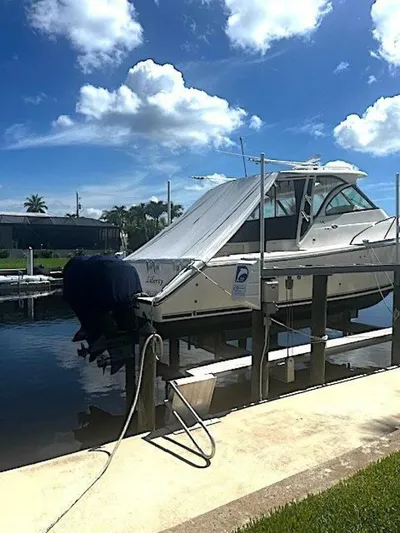 Liberty Yacht Photos Pics 2010 Pursuit OS 345 Offshore boat docked on a lift under a sunny sky.