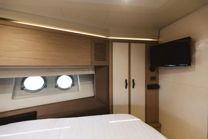  Yacht Photos Pics Luxurious cabin interior of 2015 Beneteau Monte Carlo 5 yacht with portholes and TV.