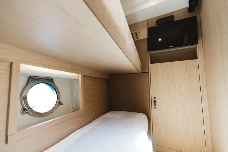  Yacht Photos Pics Interior cabin of 2015 Beneteau Monte Carlo 5 yacht with porthole and TV.