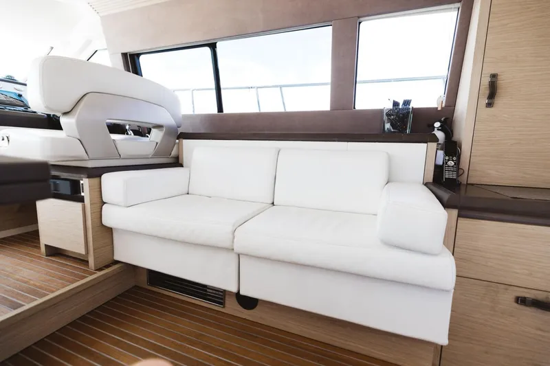  Yacht Photos Pics Luxurious interior of 2015 Beneteau Monte Carlo 5 yacht with white sofa and wooden flooring.