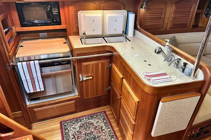 Champagne Lady Yacht Photos Pics Luxurious 2007 Sabre 386 yacht kitchen with wood cabinetry, sink, and appliances.