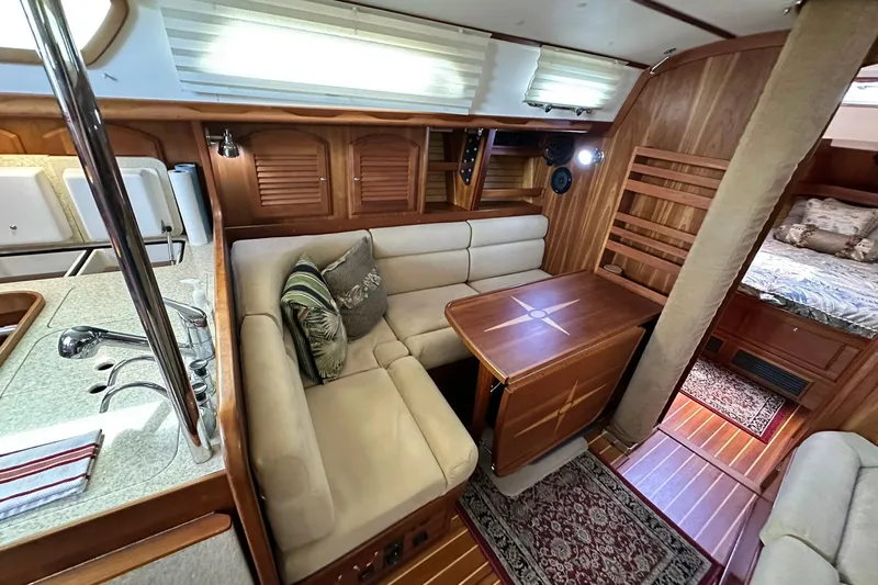 Champagne Lady Yacht Photos Pics Luxurious 2007 Sabre 386 yacht interior with cozy seating, wooden table, and elegant decor.