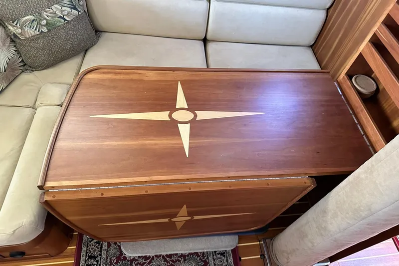 Champagne Lady Yacht Photos Pics Wooden table with compass rose design in a 2007 Sabre 386 yacht interior.
