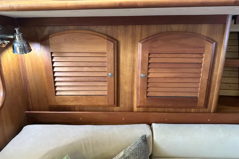 Champagne Lady Yacht Photos Pics Wooden interior of a 2007 Sabre 386 yacht with louvered cabinets and a cozy sofa.