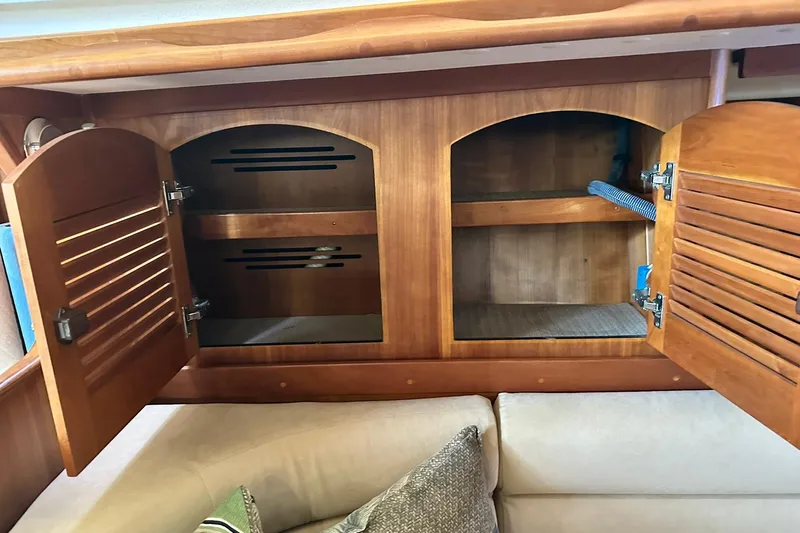 Champagne Lady Yacht Photos Pics Wooden cabinet with open doors inside a 2007 Sabre 386 yacht, revealing storage space.