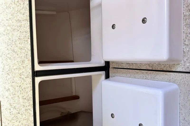 Champagne Lady Yacht Photos Pics Interior storage compartments of a 2007 Sabre 386 boat, featuring white panels and shelving.