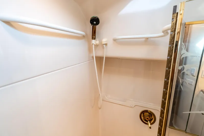 Magic Yacht Photos Pics Shower area in 1992 Tiara Yachts 4300 Open, featuring white walls and gold accents.