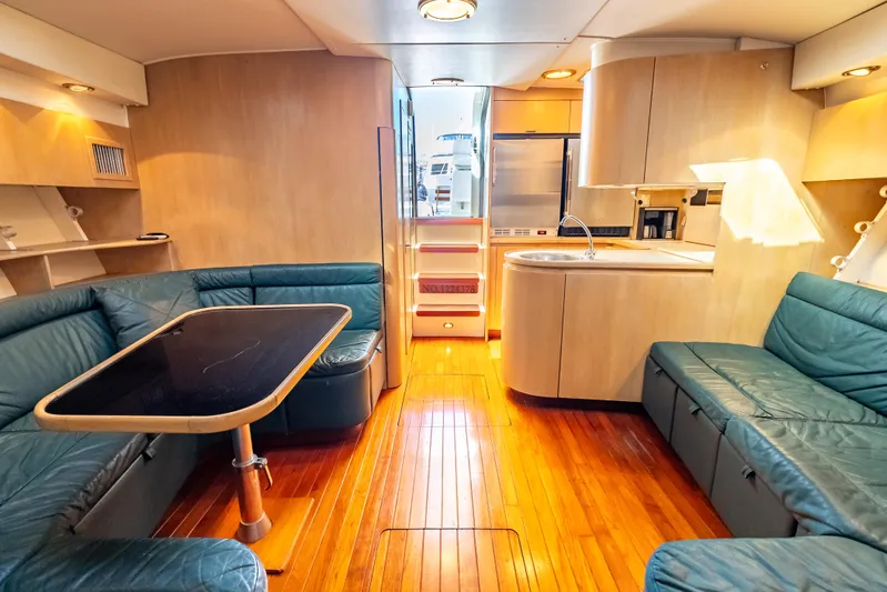 Magic Yacht Photos Pics Interior of 1992 Tiara Yachts 4300 Open with wood flooring and blue seating.