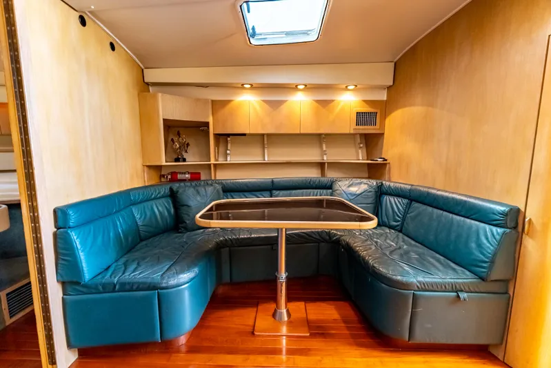 Magic Yacht Photos Pics 1992 Tiara Yachts 4300 Open interior with blue leather seating and wooden flooring.