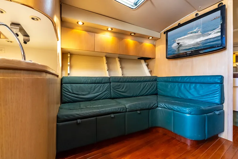 Magic Yacht Photos Pics Luxurious interior of 1992 Tiara Yachts 4300 Open with teal seating and wood flooring.