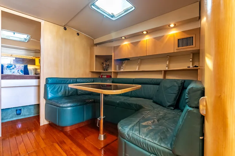 Magic Yacht Photos Pics 1992 Tiara Yachts 4300 Open interior with green leather seating and wooden flooring.