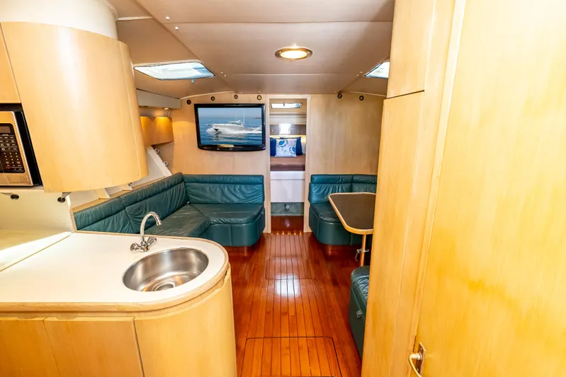 Magic Yacht Photos Pics Luxurious interior of 1992 Tiara Yachts 4300 Open with wood flooring and teal seating.