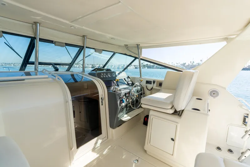 Magic Yacht Photos Pics 1992 Tiara Yachts 4300 Open helm with white seating and panoramic windows.