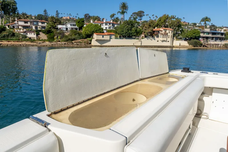 Magic Yacht Photos Pics 1992 Tiara Yachts 4300 Open boat with open storage compartment, coastal background.