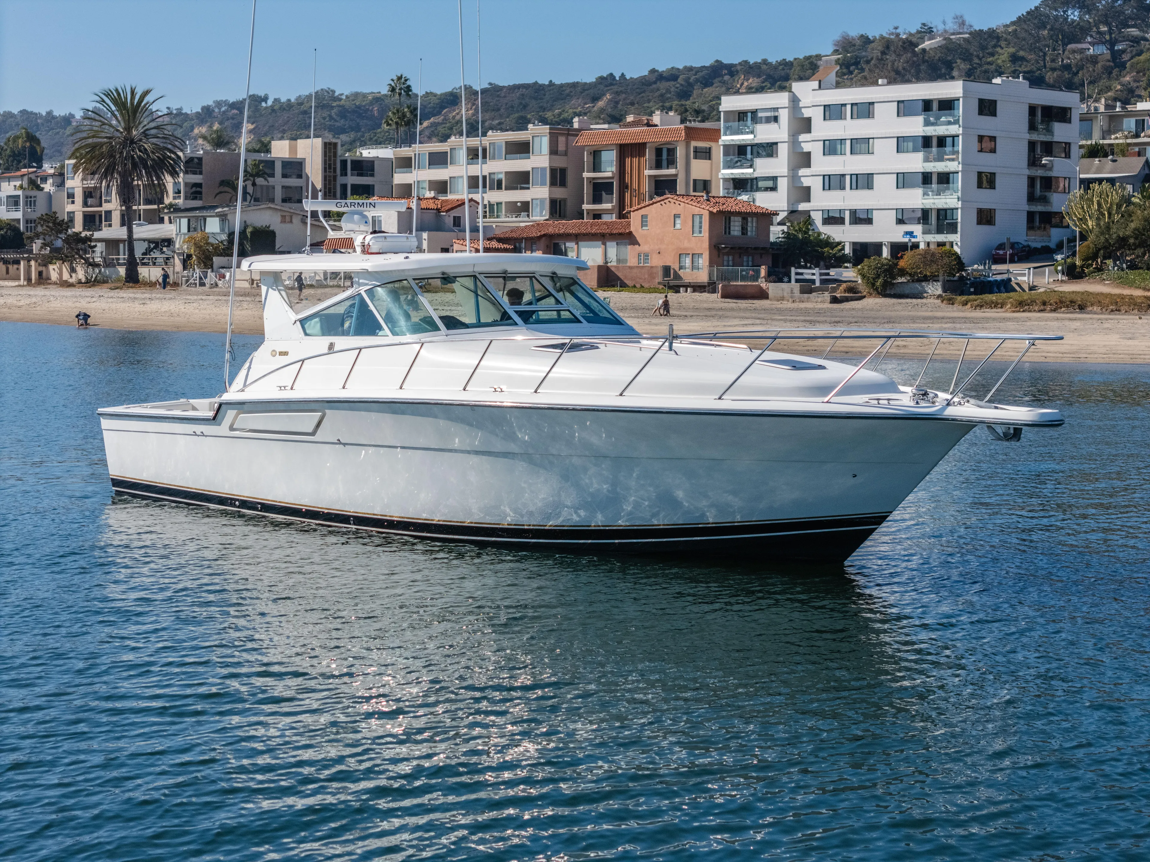 Magic Yacht Photos Pics 1992 Tiara Yachts 4300 Open cruising near a coastal residential area.