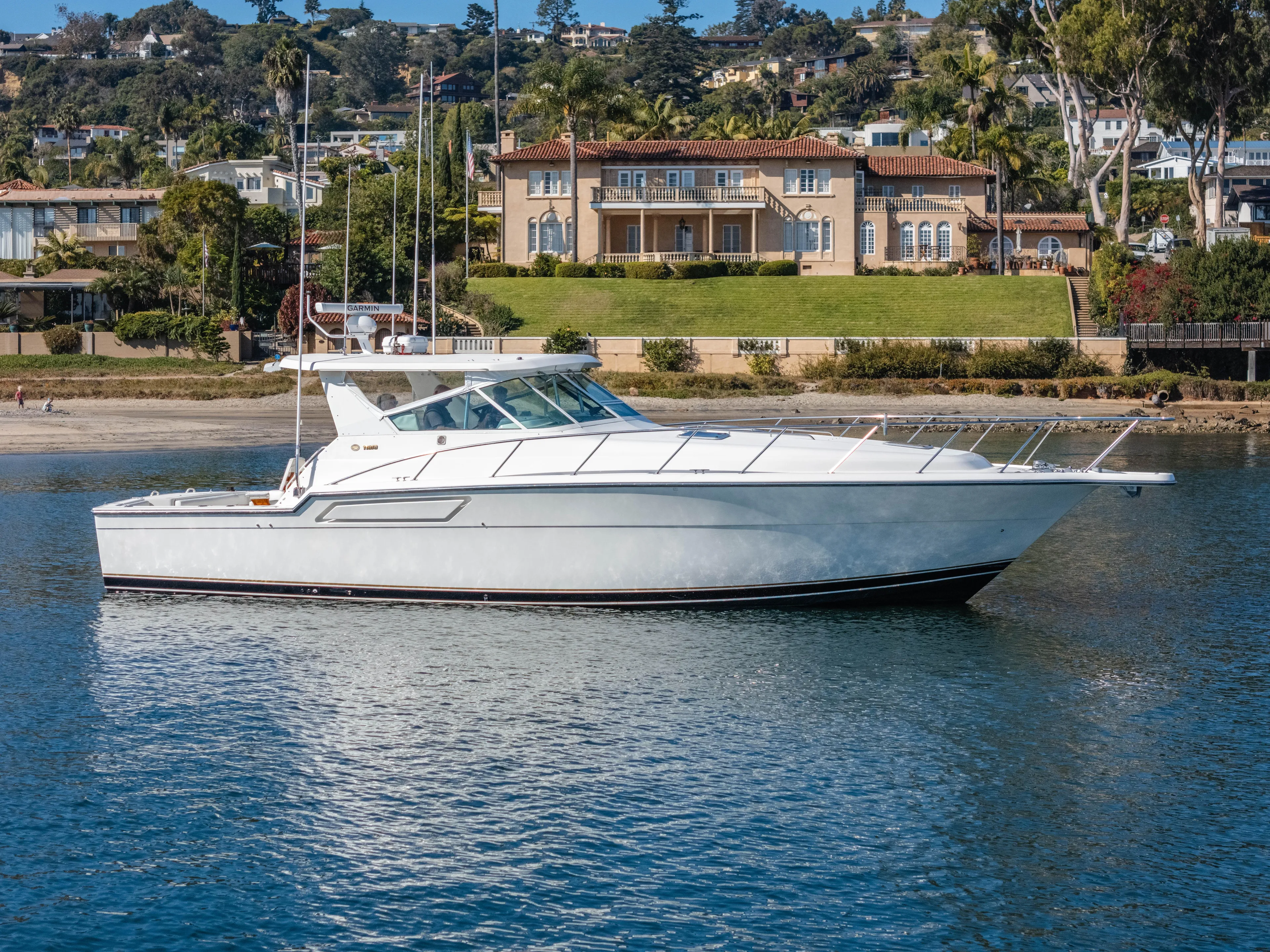 Magic Yacht Photos Pics 1992 Tiara Yachts 4300 Open cruising on calm waters near luxury waterfront homes.