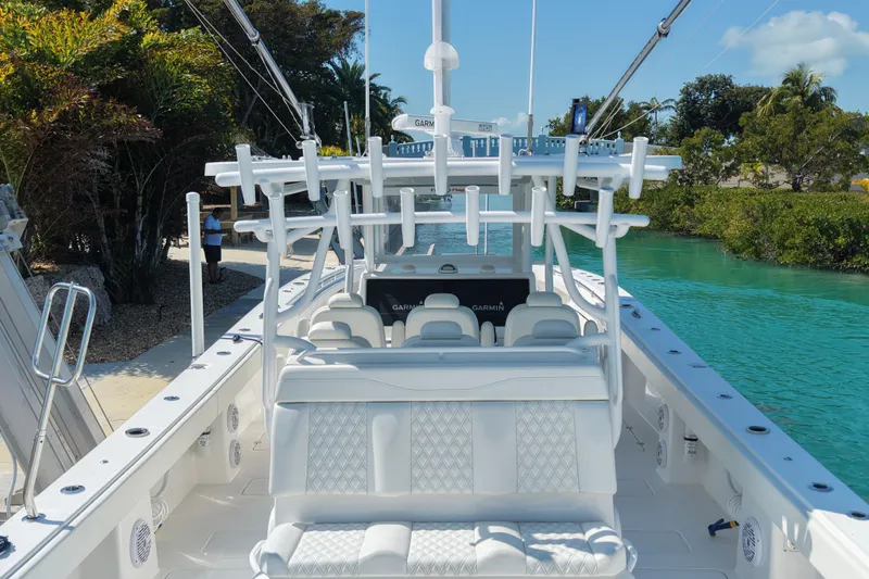  Yacht Photos Pics 2023 Invincible 46 Catamaran with luxurious seating, docked by turquoise water and lush greenery.