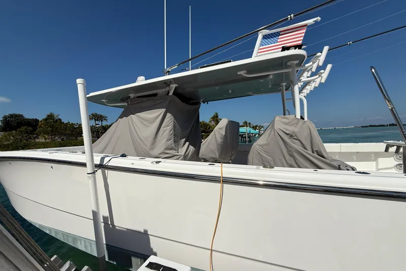  Yacht Photos Pics 2023 Invincible 46 Catamaran docked, covered seats, American flag, sunny day.